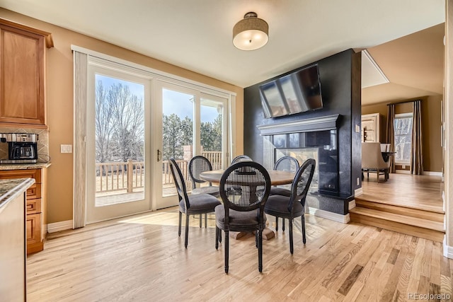 6790 W Crestline Ave, Littleton, CO 80123 - dining space featuring a multi sided fireplace, light wood finished floors, and baseboards