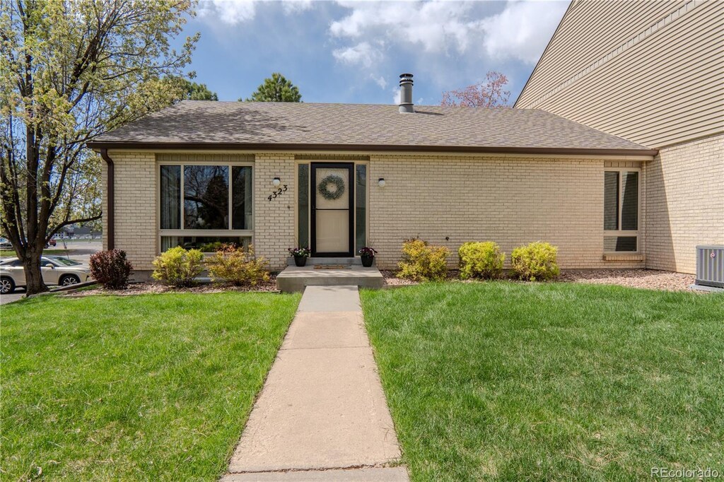 4323 W Ponds Cir, Littleton, CO 80123 - single story home featuring a shingled roof, brick siding, and a front yard