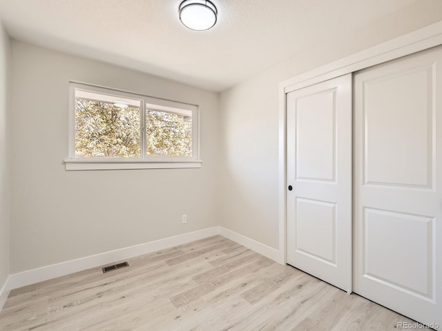 unfurnished bedroom with a closet and light hardwood / wood-style flooring