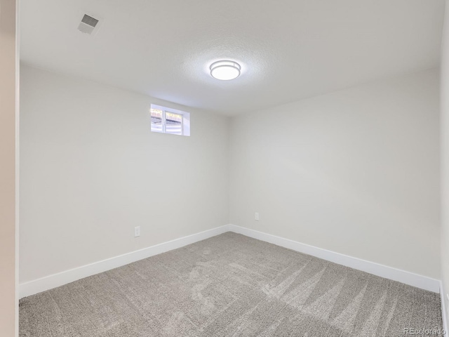 carpeted empty room featuring a textured ceiling