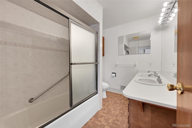 5621 Demott Ave, Commerce City, CO 80022 - full bathroom with vanity, toilet, and combined bath / shower with glass door