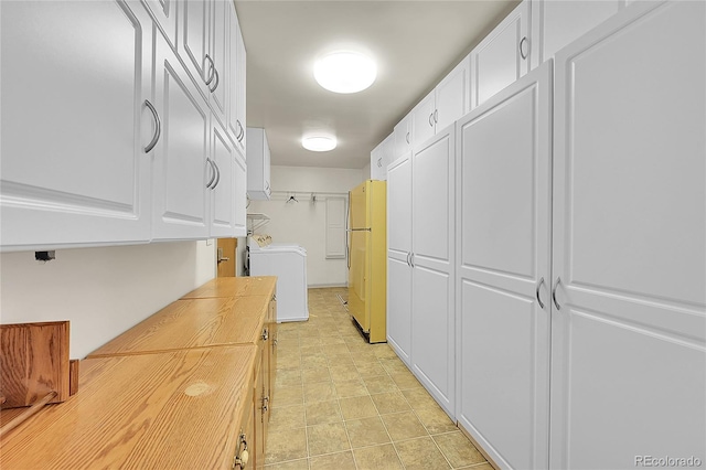 5621 Demott Ave, Commerce City, CO 80022 - kitchen featuring fridge, washer / dryer, butcher block countertops, and white cabinets