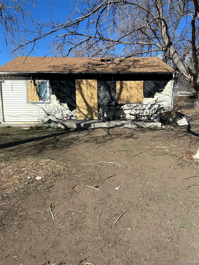view of front facade with an attached carport and roof with shingles