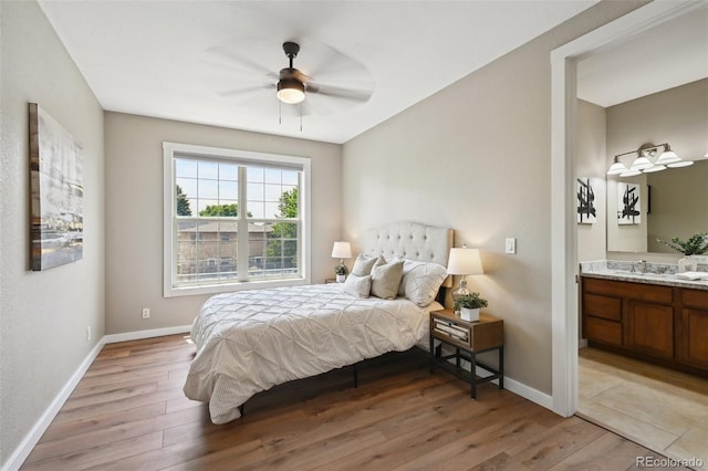 3482 E 28th Ave, Denver, CO 80205 - bedroom featuring light wood-style floors, baseboards, a sink, and ensuite bath