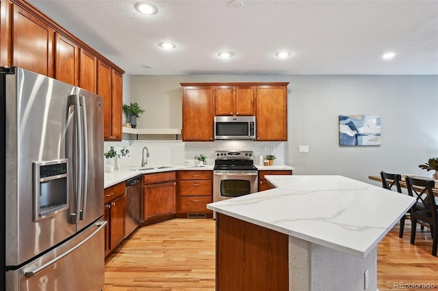 3482 E 28th Ave, Denver, CO 80205 - kitchen featuring appliances with stainless steel finishes, a sink, light wood finished floors, a kitchen island, and recessed lighting