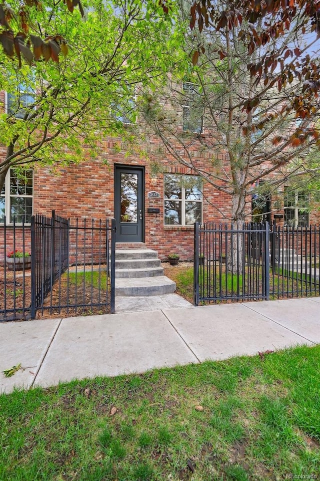 3482 E 28th Ave, Denver, CO 80205 - view of front facade featuring a fenced front yard, brick siding, and a gate