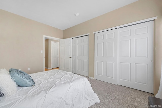 bedroom with light carpet and multiple closets