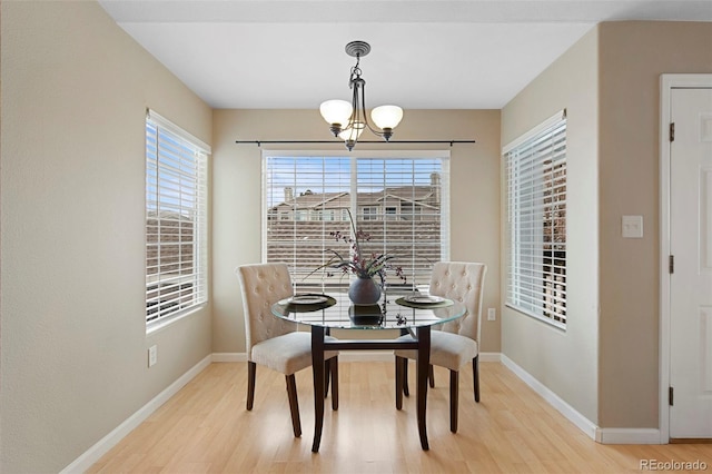 dining space featuring a healthy amount of sunlight, a chandelier, and light wood-type flooring