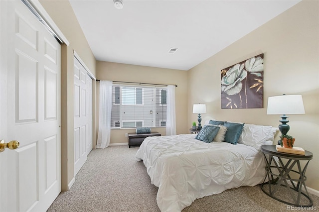 carpeted bedroom with baseboards, visible vents, and a closet