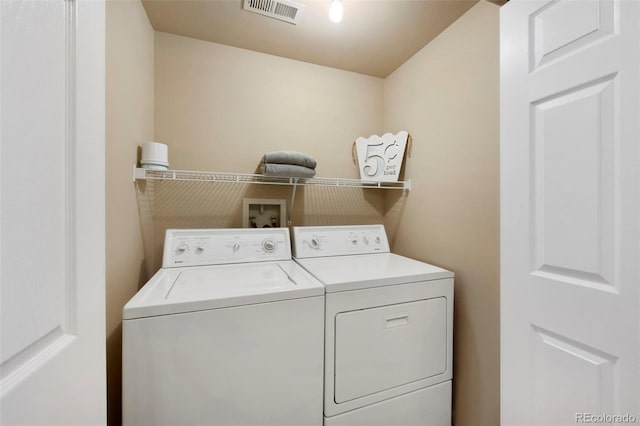 clothes washing area with visible vents, laundry area, and washer and dryer