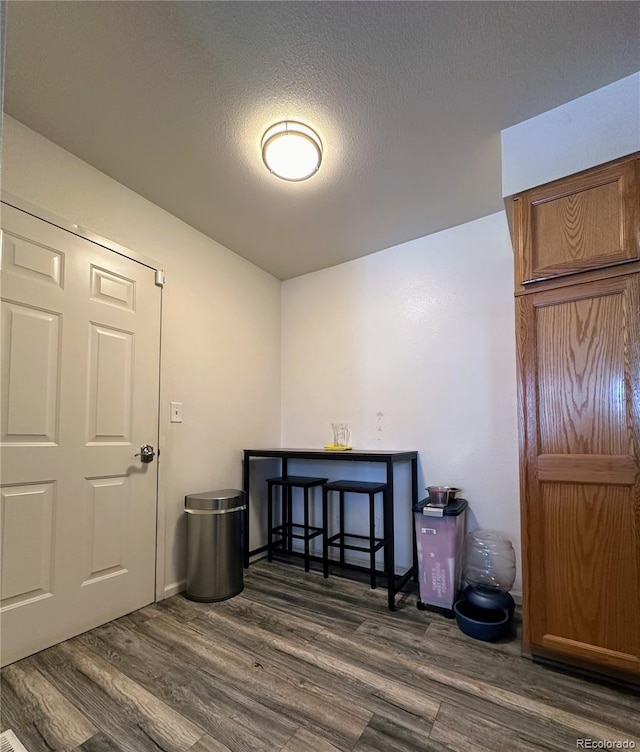 empty room with dark wood-type flooring and a textured ceiling