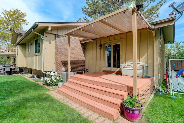 8866 E Easter Ave, Centennial, CO 80112 - rear view of house featuring a deck, board and batten siding, a lawn, and brick siding