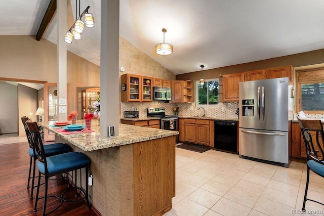 8866 E Easter Ave, Centennial, CO 80112 - kitchen with stainless steel appliances, brown cabinetry, a sink, glass insert cabinets, and a kitchen bar