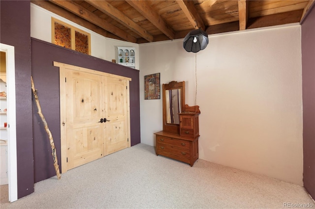 bedroom with beamed ceiling, wood ceiling, and light carpet