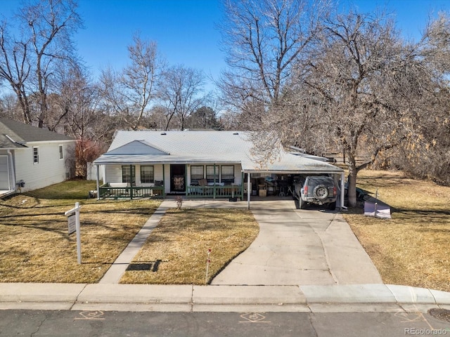 ranch-style home featuring a front yard, a carport, and covered porch