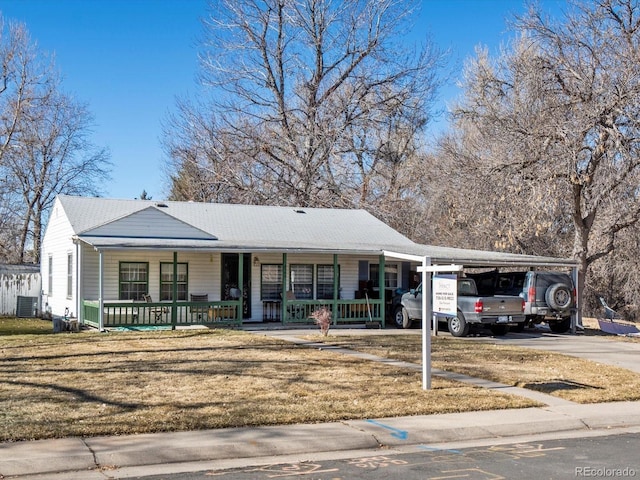 view of front of house with central AC unit, a front lawn, a carport, and covered porch