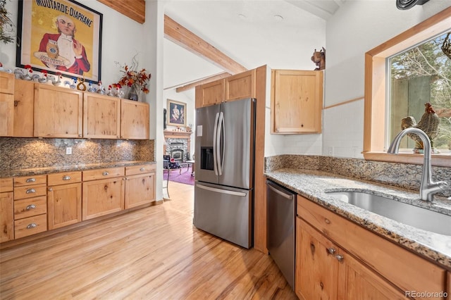 32209 Blue Springs Dr, Evergreen, CO 80439 - kitchen with appliances with stainless steel finishes, a sink, light wood-style flooring, backsplash, and light stone countertops