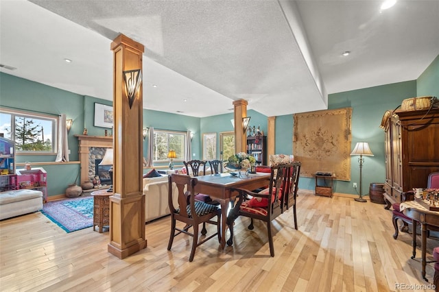 32209 Blue Springs Dr, Evergreen, CO 80439 - dining space with decorative columns, light wood-style flooring, and plenty of natural light