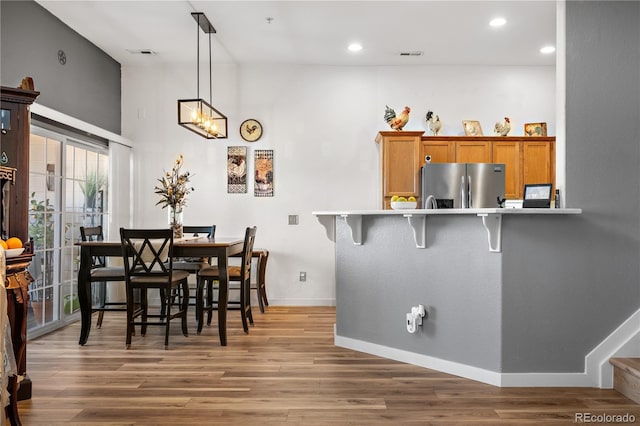 8944 Fox Dr Unit 6-103, Denver, CO 80260 - dining space featuring wood finished floors, baseboards, recessed lighting, a towering ceiling, and a chandelier