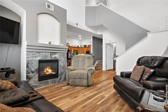 8944 Fox Dr Unit 6-103, Denver, CO 80260 - living area featuring a towering ceiling, light wood-style flooring, stairs, and a fireplace