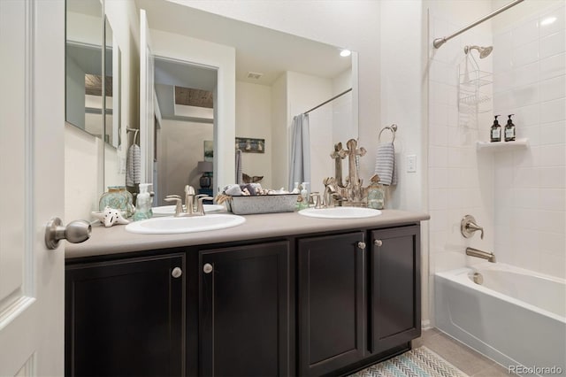 bathroom with double vanity, tile patterned flooring, shower / bath combo with shower curtain, and a sink