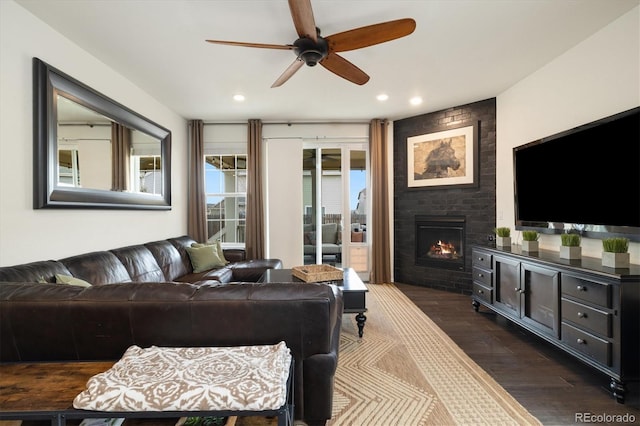 living room featuring dark wood-style floors, a large fireplace, a ceiling fan, and recessed lighting