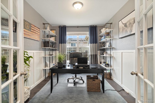 office with french doors, dark wood-type flooring, and wainscoting