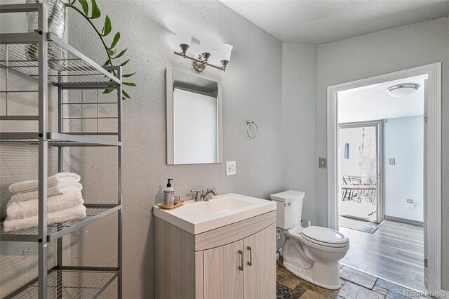 3768 S Acoma St, Englewood, CO 80110 - half bath with toilet, stone tile flooring, and vanity
