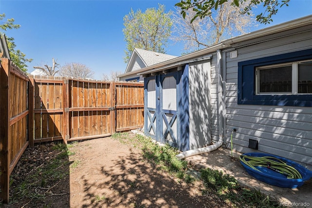 3768 S Acoma St, Englewood, CO 80110 - view of side of property featuring a storage unit, a gate, fence, and an outbuilding