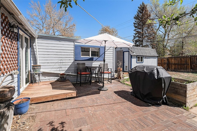 3768 S Acoma St, Englewood, CO 80110 - view of patio with grilling area, a deck, a fenced backyard, an outbuilding, and outdoor dining space