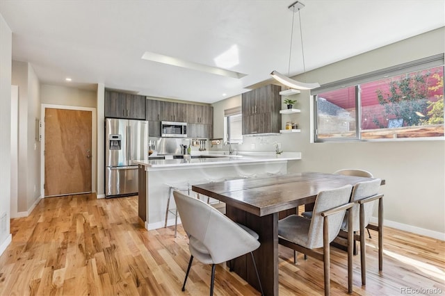 dining space with light hardwood / wood-style floors and plenty of natural light