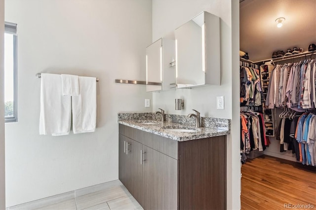 interior space featuring light stone counters, light hardwood / wood-style flooring, and sink