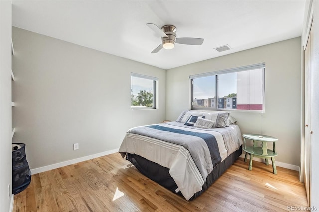 bedroom with ceiling fan, a closet, and light hardwood / wood-style floors