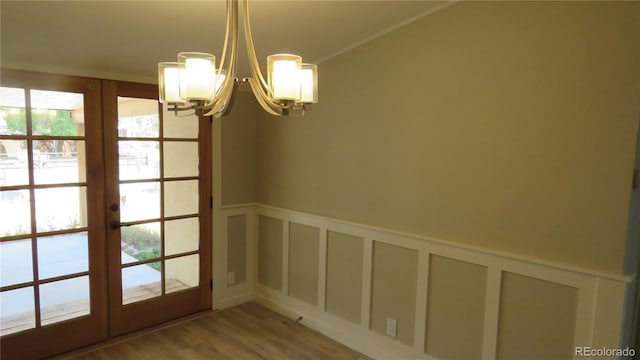 150 Palmer Ave, Poncha Springs, CO 81242 - unfurnished dining area featuring a chandelier, french doors, a decorative wall, wood finished floors, and wainscoting