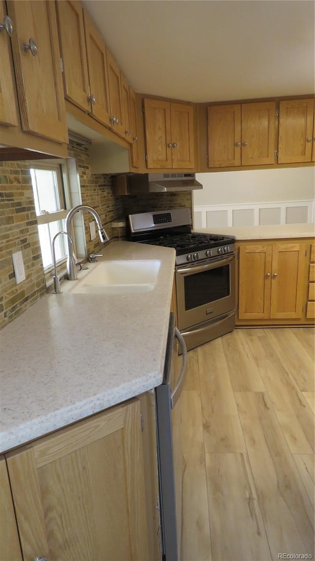 150 Palmer Ave, Poncha Springs, CO 81242 - kitchen featuring appliances with stainless steel finishes, light wood-type flooring, backsplash, and brown cabinetry