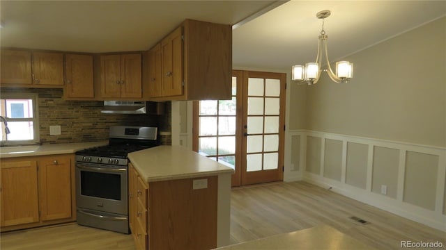 150 Palmer Ave, Poncha Springs, CO 81242 - kitchen featuring stainless steel gas range oven, under cabinet range hood, light wood-style flooring, light countertops, and a wainscoted wall