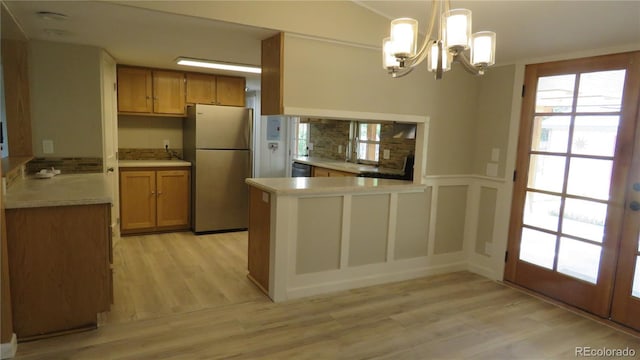 150 Palmer Ave, Poncha Springs, CO 81242 - kitchen featuring stainless steel appliances, a peninsula, light wood-style flooring, and a chandelier