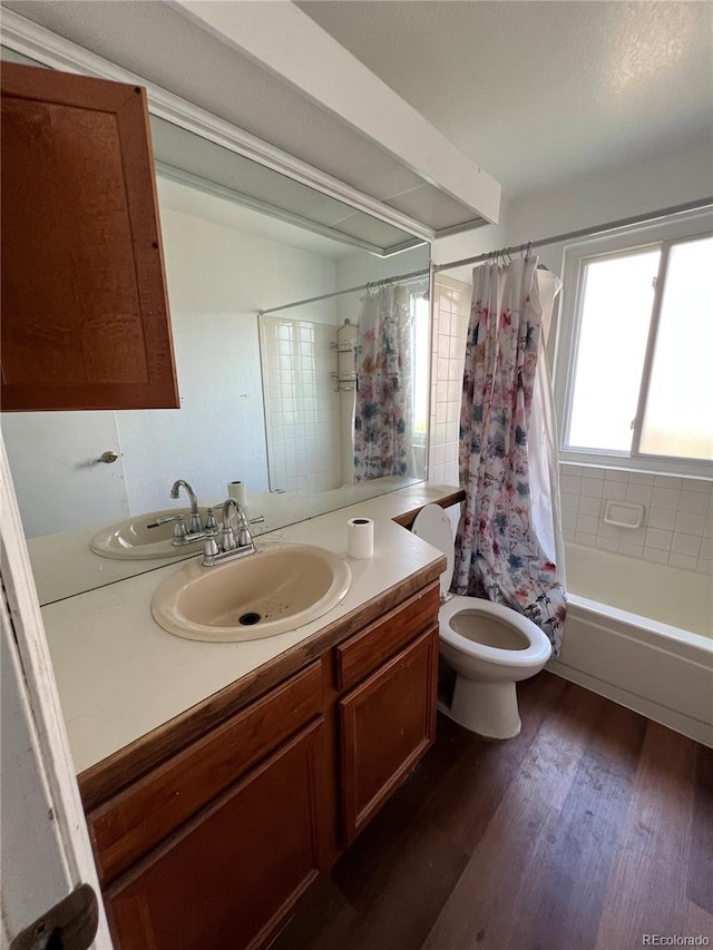 full bathroom with hardwood / wood-style floors, vanity, shower / bath combination with curtain, and toilet