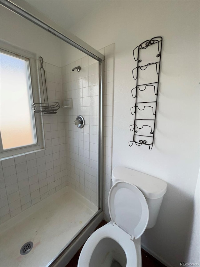 bathroom featuring tiled shower and toilet