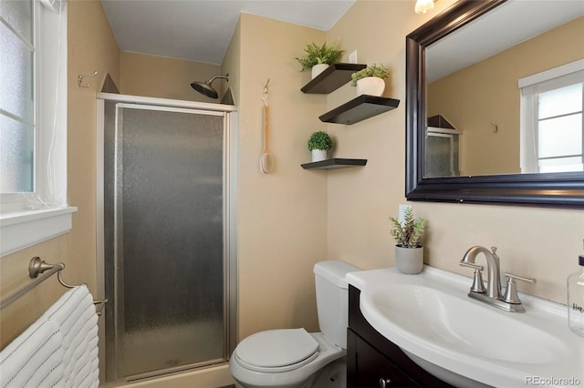 bathroom with walk in shower, vanity, and toilet