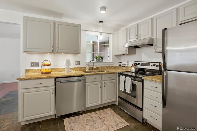 kitchen with sink, light stone counters, hanging light fixtures, appliances with stainless steel finishes, and white cabinets