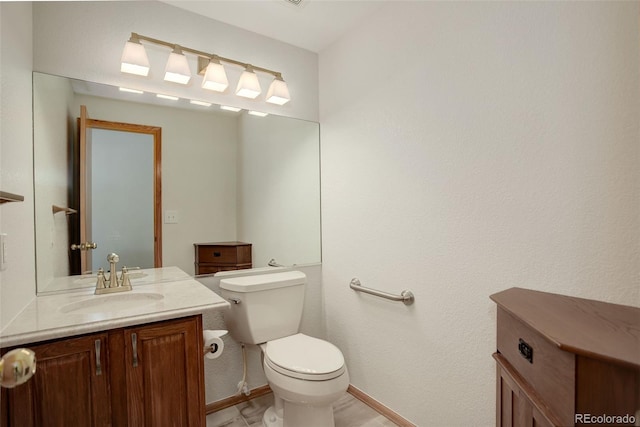 bathroom featuring toilet, vanity, and baseboards