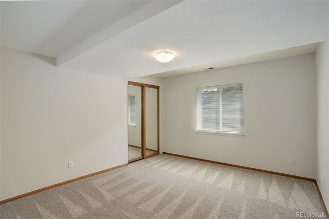 unfurnished room with light carpet and baseboards