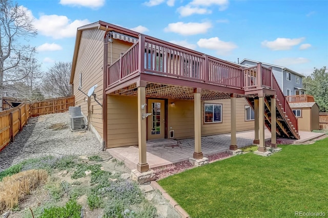 back of property with a deck, a patio area, a storage shed, an outbuilding, and stairway