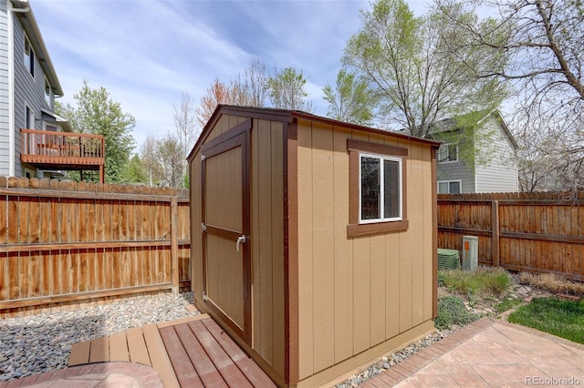 view of shed with a fenced backyard and central AC unit