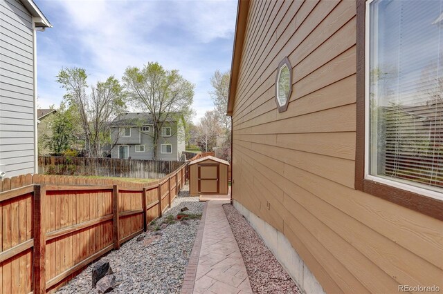 view of home's exterior featuring a fenced backyard, a storage shed, and an outbuilding