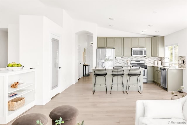 5282 E 116th Ave, Thornton, CO 80233 - kitchen with appliances with stainless steel finishes, gray cabinets, vaulted ceiling, arched walkways, and a kitchen breakfast bar