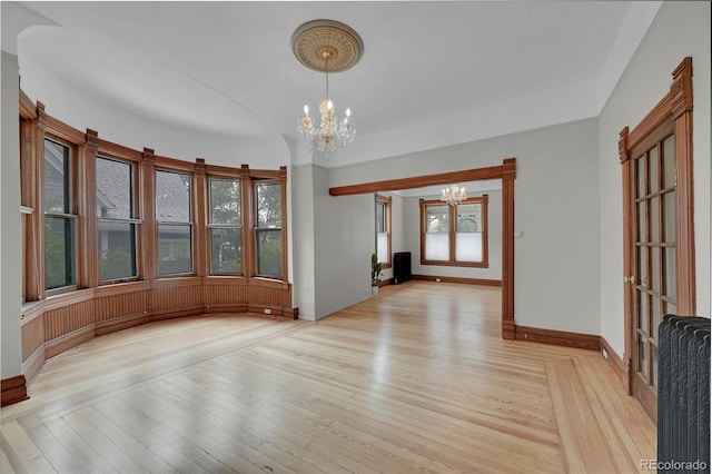 interior space with light wood finished floors, baseboards, and an inviting chandelier