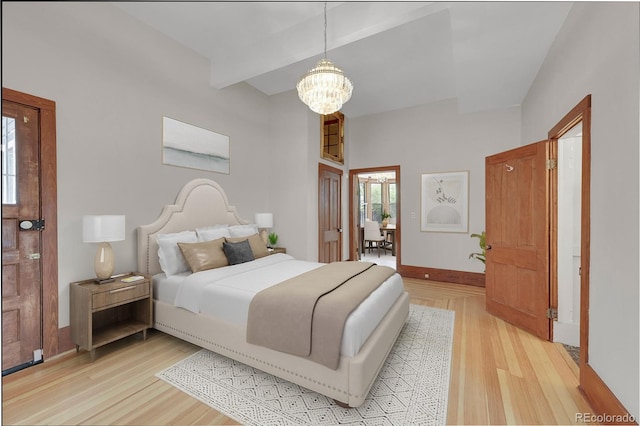 bedroom featuring an inviting chandelier, baseboards, light wood-type flooring, and beam ceiling