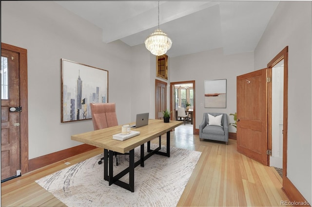 office space with baseboards, beam ceiling, light wood-style floors, and a chandelier